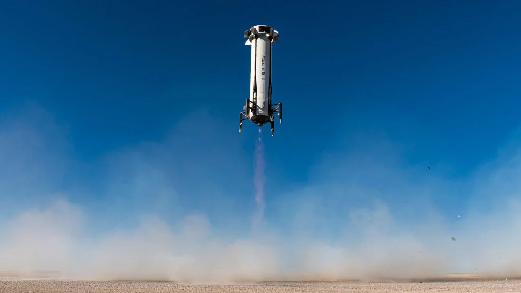 Blue Origin New Shepard rocket booster performing a vertical landing in a desert area with dust rising beneath it. History of Space Exploration